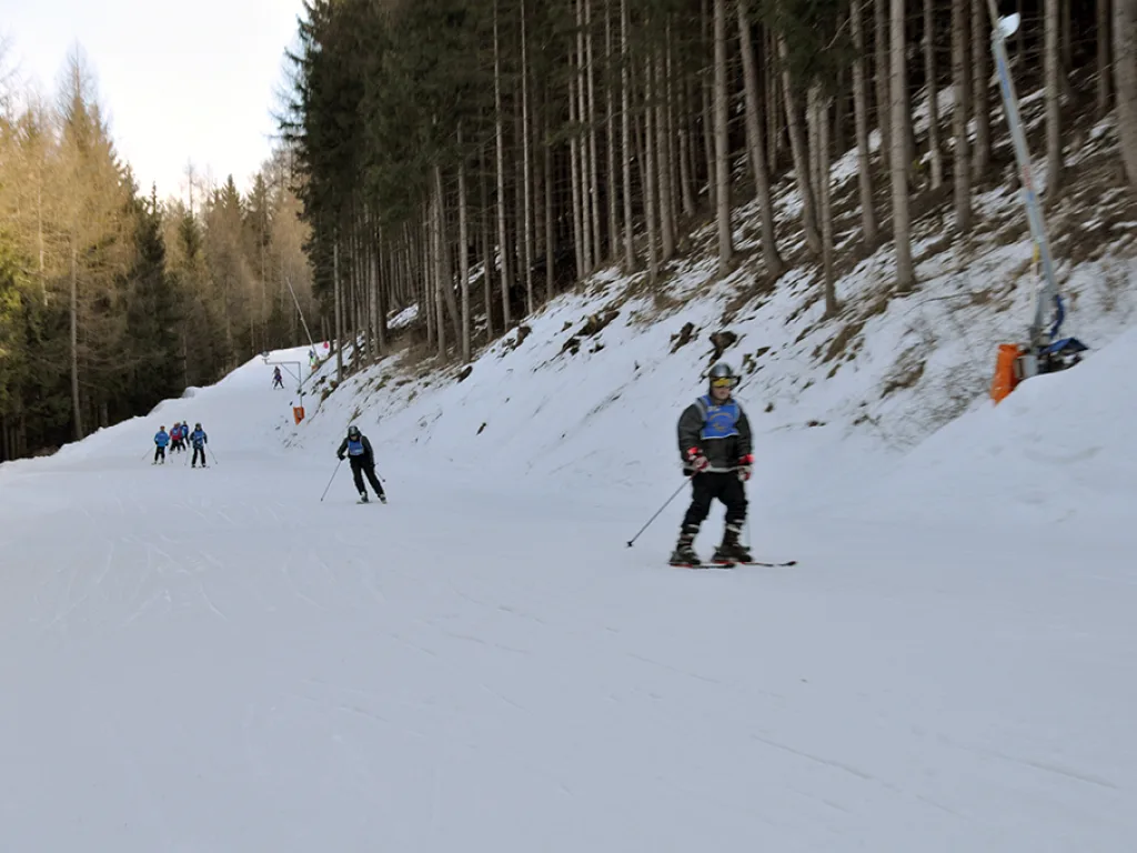 Skifahrende auf der Waldpiste.
